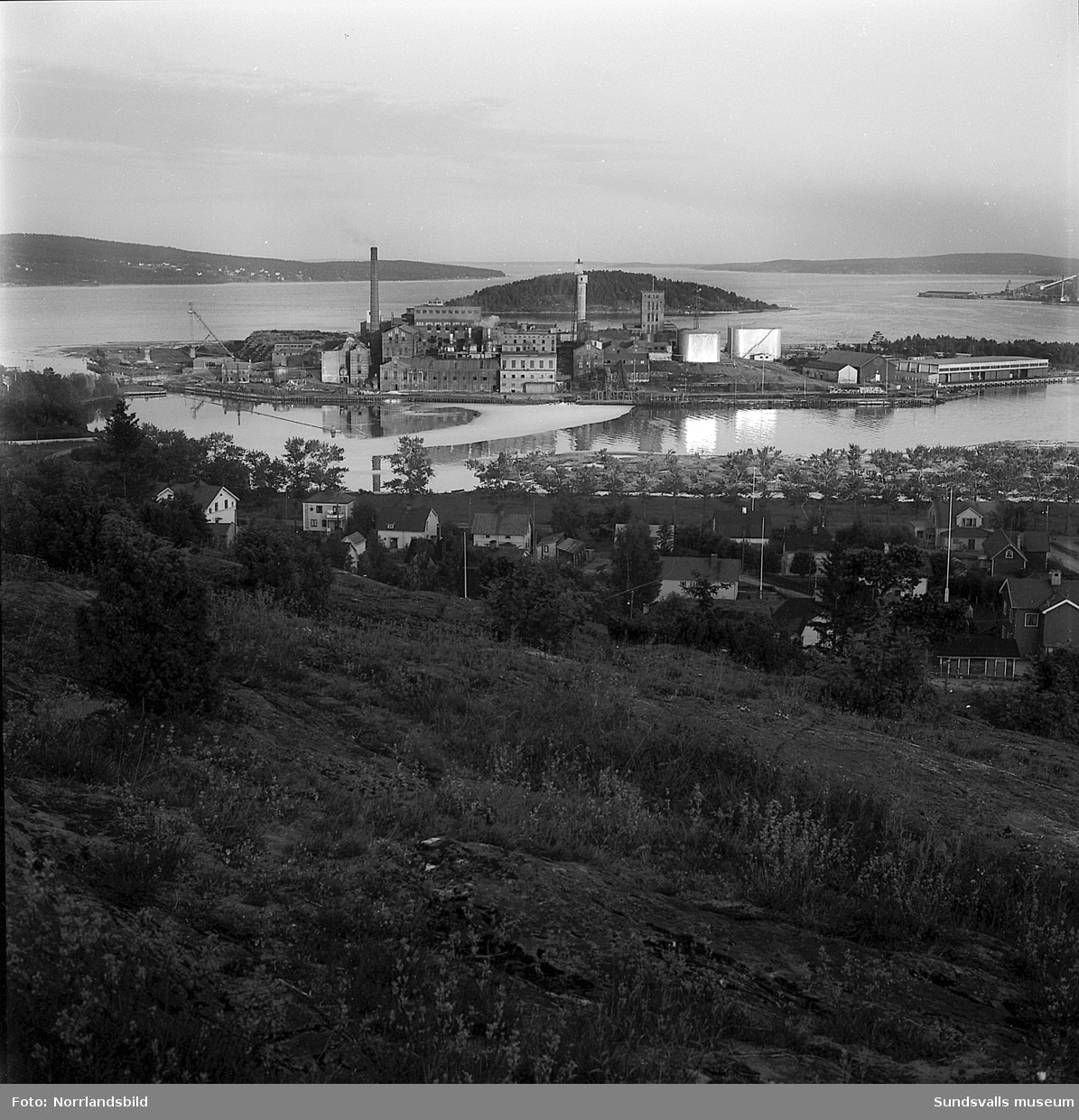 Ortvikens massafabrik. Första bilden är tagen från Ortviksberget mot fabriken med Tjuvholmen bakom. Framför syns äldre villabebyggelse i kvarteren Sjölejonet och Sjöängen, varav en del av husen står kvar än i dag (2016).
