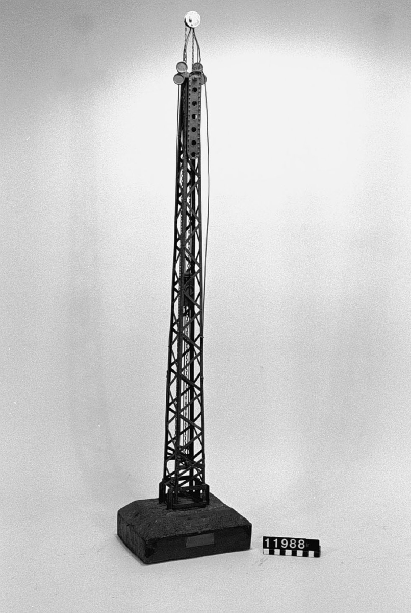 Modell av järn till semafor för järnvägar, två vingar och växling av lyktskenets färg. Skylt på foten: "F Arvidsson Posses Patent No792  1886".