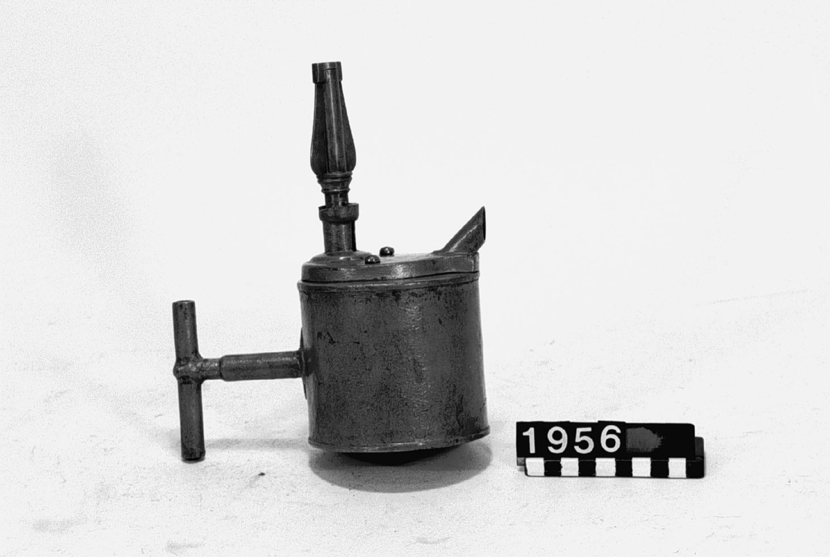 Christopher Polhem's strange tap, made of tinplate with the fixed parts riveted and soldered. The gear and its sleeve, the sleeve on the pipe and a liner in the drain of the container are made of brass. The tap is to be mounted in the barrel. The amount of liquid that is drawn out is portioned with a key. It also functioned as a lock and limited access to the barrel's contents. This specimen was probably exhibited at the 1866 exhibition in Stockholm, by "Stiernsunds Bruksegare", according to a contemporary exhibition catalogue.