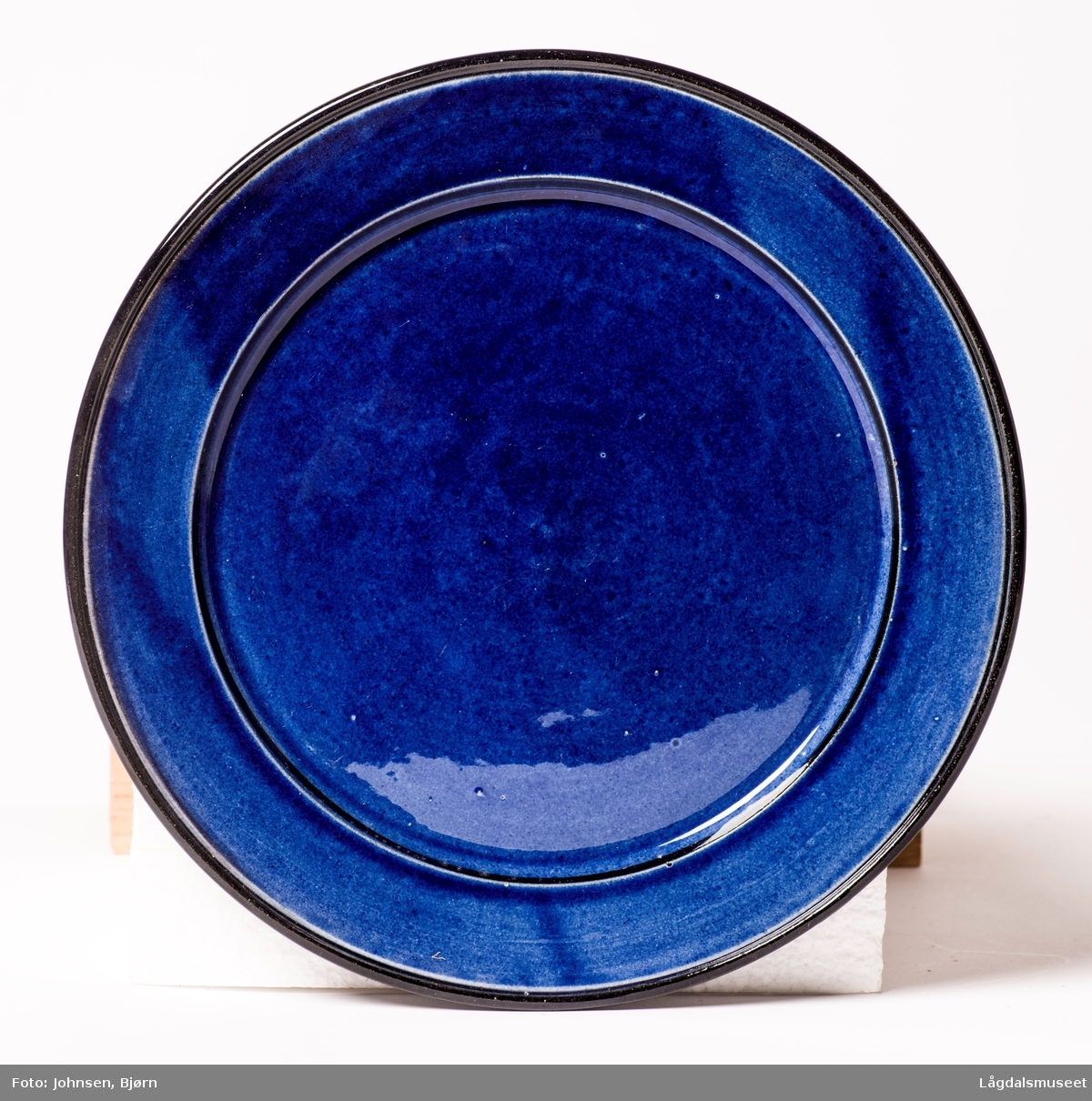 Koboltblå kopp uten dekor, svart under og blå oppå.
