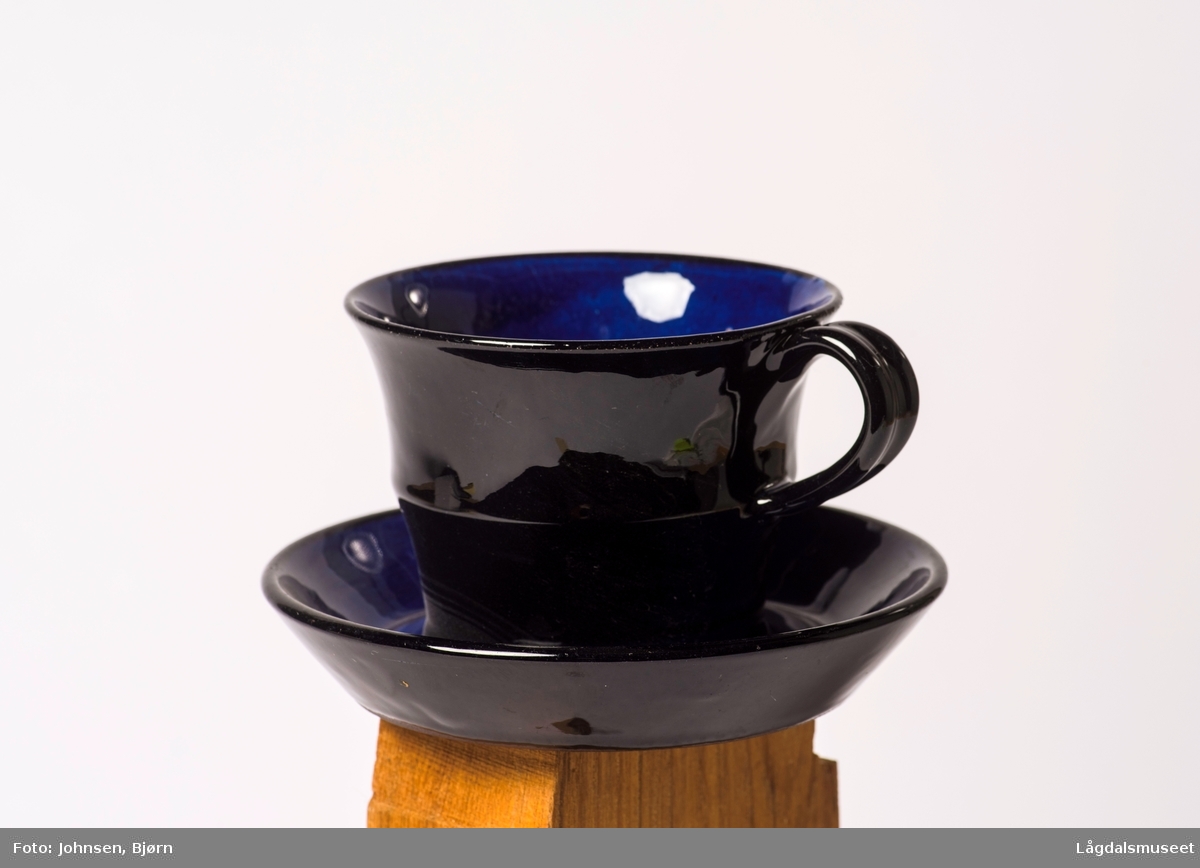 Koboltblå kopp uten dekor, svart utenpå og blå inni.