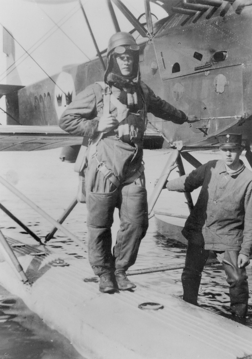 En militär flygare och en flygmekaniker står vid flottörerna på sjöflygplan S 1 på flygstationen i Karlsborg.