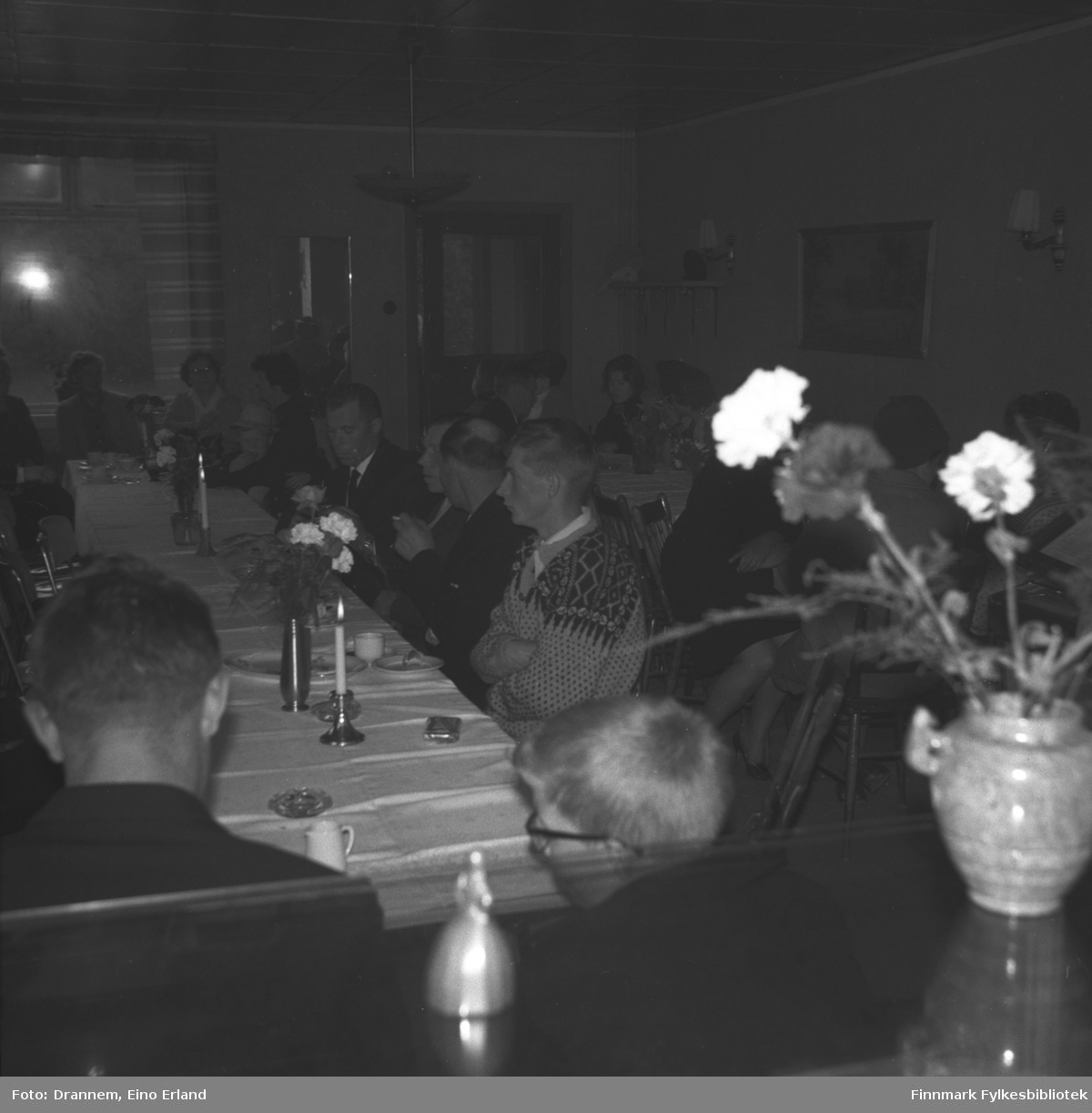 Mange personer sitter ved langbord i et lokale i Neiden. Dette kan være fra Alfred Karikoskis begravelse i august 1965.