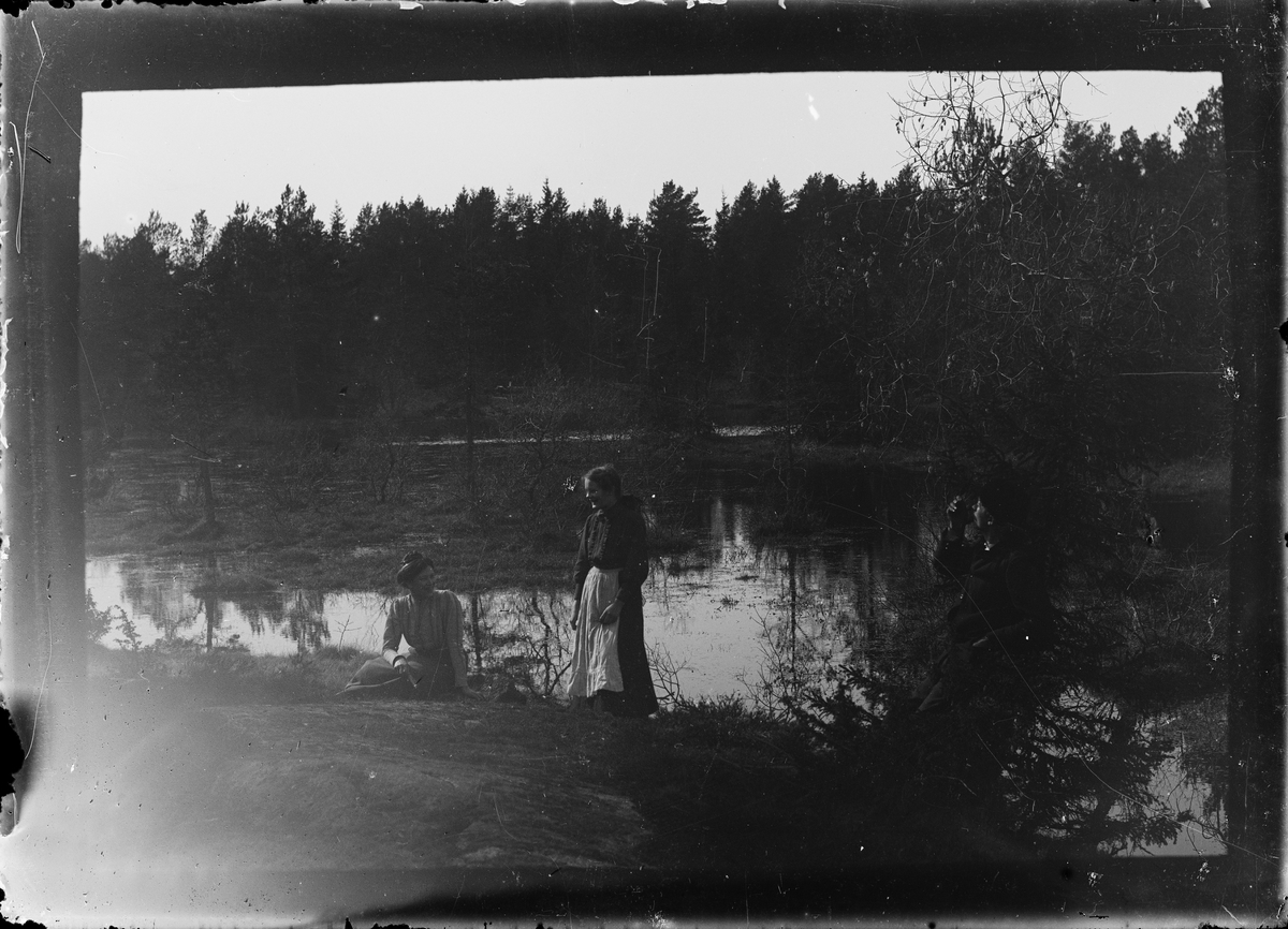 Man och två kvinnor vid vattendrag, Alunda, Uppland