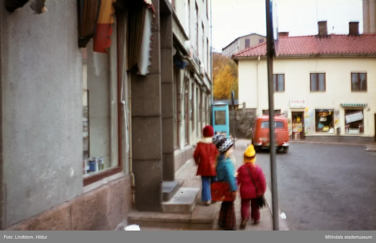 Tre små flickor utanför huset Kvarnbygatan 43 vid Gamla Torget i Mölndal, 1970-tal. Huset var tidigare Mölndals stadshus, sedermera musikskola. I bakgrunden ses även huset Kvarnbygatan 45.

För mer information om bilden se under tilläggsinformation.