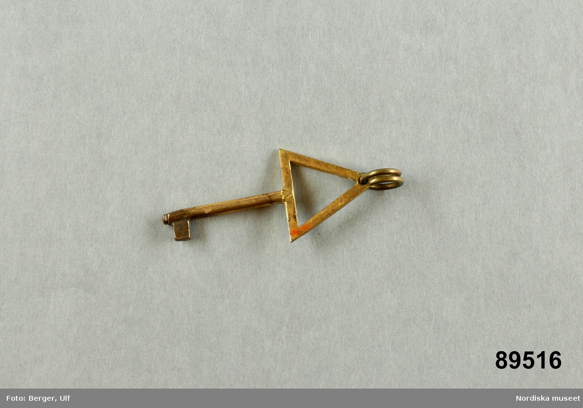 Huvudliggaren:
"Föreningstecken. Mässing, i form av nyckel med trekantig överdel.
G. 15/6 1900 [från] doktor H. Kempff, Stockholm.
