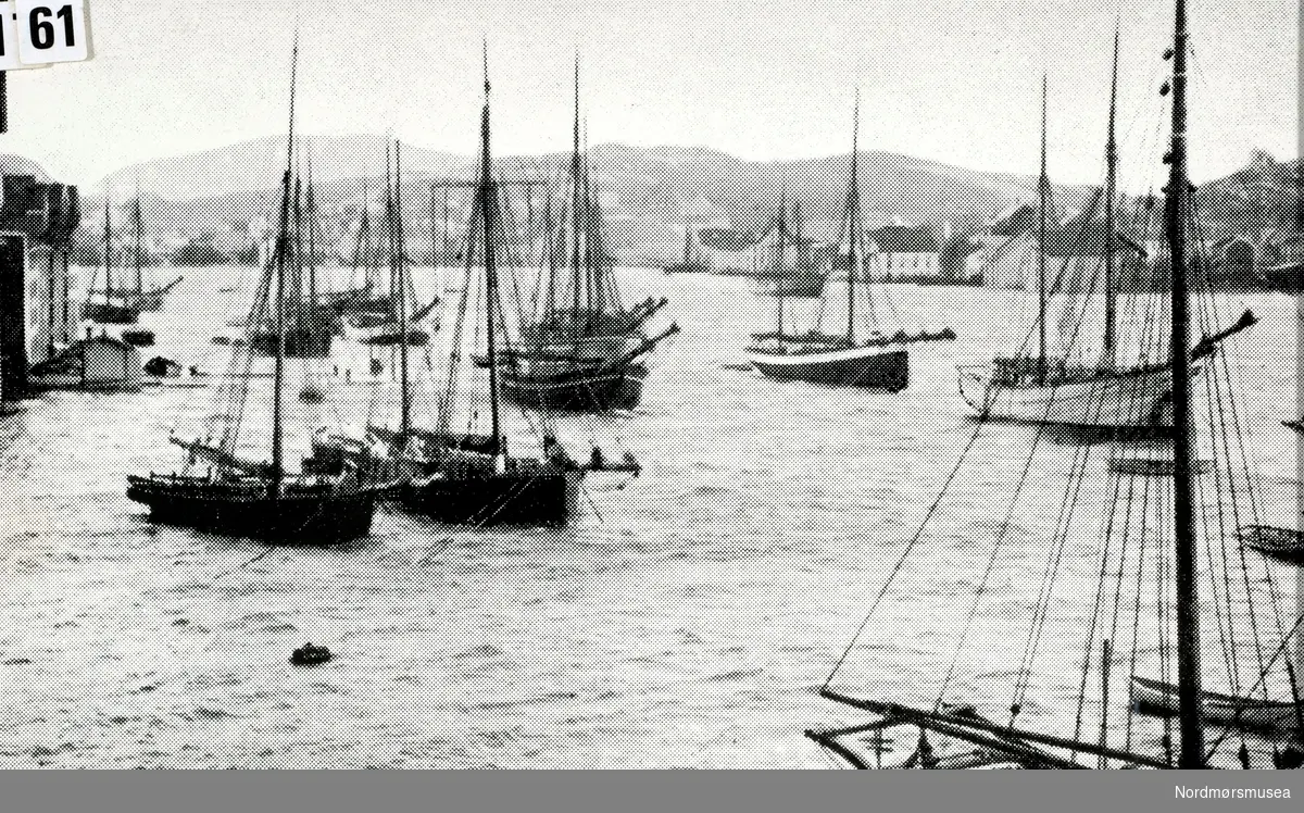 Bildet viser Sørsundet med Kirklandet til venstre og Innlandet til høyre. I bakgrunnen ses Nordlandet. - Storm i havnebassenget i Kristiansund, hvor vi ser diverse skip  liggende oppankret. Bildet er datert omkring 1900. Fotograf er ukjent. Fra Nordmøre Museums fotosamlinger.