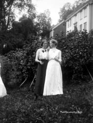 Foto av to kvinner i en hage. Kvinnene er enten familie elle