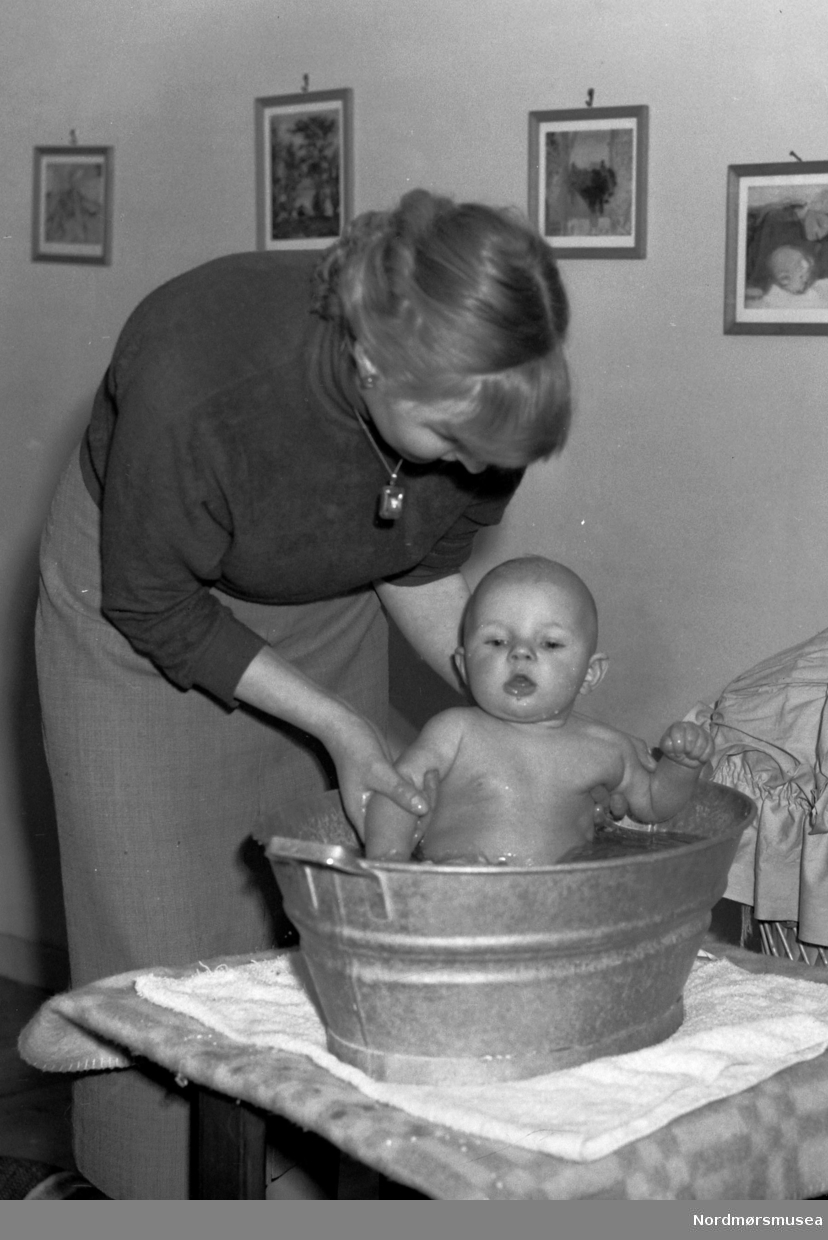 Kvinne bader et lite barn i en sinkbalje. Fra Nordmøre Museum sin fotosamling, Williamsarkivet. EFR2015
