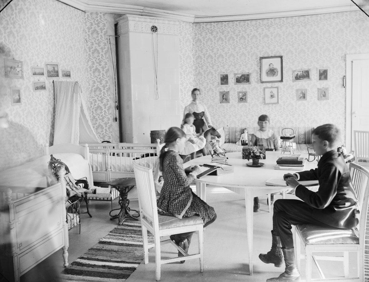 Lek och läxläsning i barnkammaren på en bild från slutet av 1890-talet.