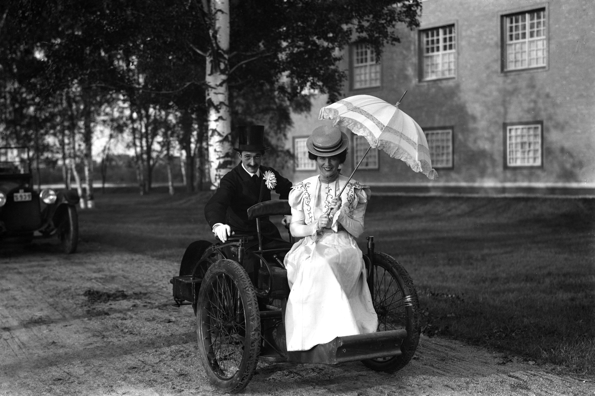 Bildsvit från det historiska festtåget, ett inslag i Värmlandsutställningen år 1929. Fordonet, en trehjulig Léon-Bollée av 1897-års modell var en av de första bilarna som kom till Sverige, här inlånad från Tekniska museet till utställningen.