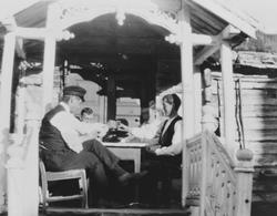 Fire menn sitter rundt et bord i et bislag og skåler