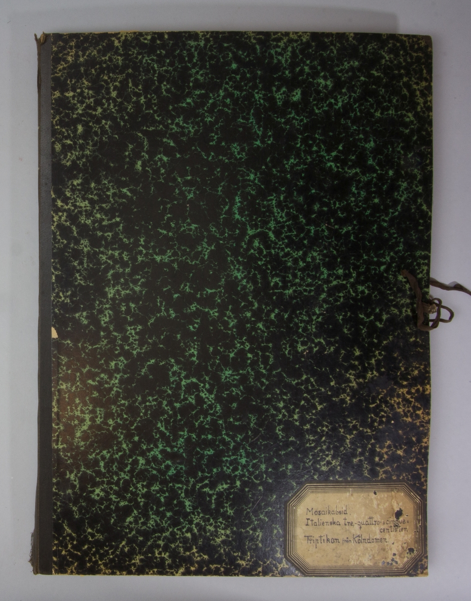 Portfölj av marmorerad papp. Sammanhållen med knytband. Rygg av svart linne. Innehåller enbart flera exemplar av Stockholms Tidningen från 1915.