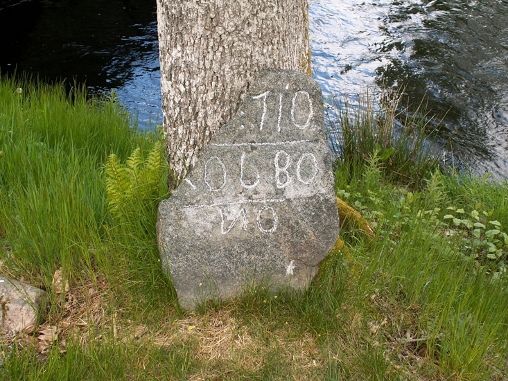 Väghållningssten
Foto av väghållningsten. På östra sidan är inskriptionen: "710 / OLBO".
Stenen står löst lutad mot ett träd.  Har sannolikt även flyttats något.
Raä 219 a, 2008-04-09, reg i FMIS.
