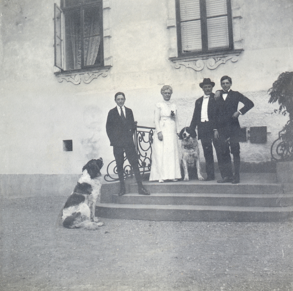 Caroline och Claes Lagergren med de två sönerna Carl (född 1899) och Johan (född 1898) samt familjens S:t Bernhardshundar på Tyresö slotts trappa. Äldste sonen Claes (född 1892) saknas i bilden.