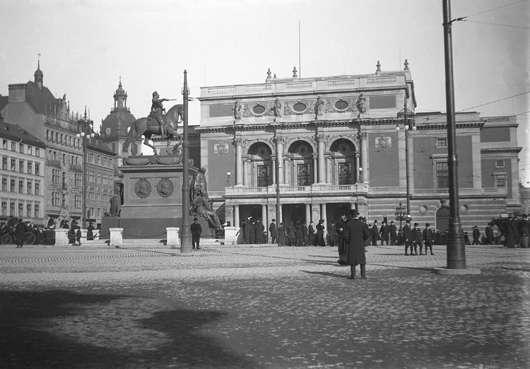 Vy av Gustaf Adolfs torg med Operan och Gustaf II Adolfs staty. 
I bakgrunden skymtar man bl a kyrktornet på Jakobs kyrka.