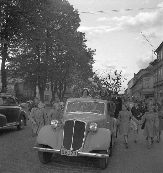 Studenterna andra dagen, 1950.
En kvinnlig student färdas i öppen bil längs Storgatan. 

Angående avgångsklasserna 1950 - se "Lärare och Studenter vid Växjö 
Högre Allmänna Läroverk 1850-1950" (1951), s. 193-196, 289.