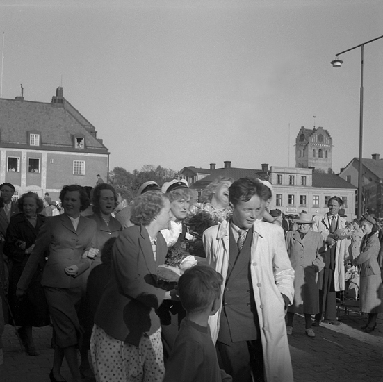 Studenterna tredje dagen, 1951.
En student bärs iväg av sina kamrater på Stortorget. I bakgrunden syns dåv. P
Post- och Riksbankshuset och domkyrkans torn.