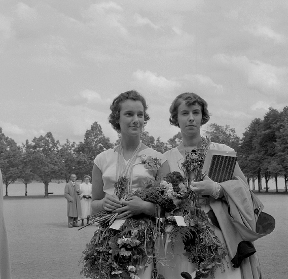 Flickskolans avslutning, 12/6 1954. 
Två unga kvinnor från avgångsklassen har ställt upp sig för fotografering 
på skolgården till dåv. Växjö Högre Allmänna Läroverk.