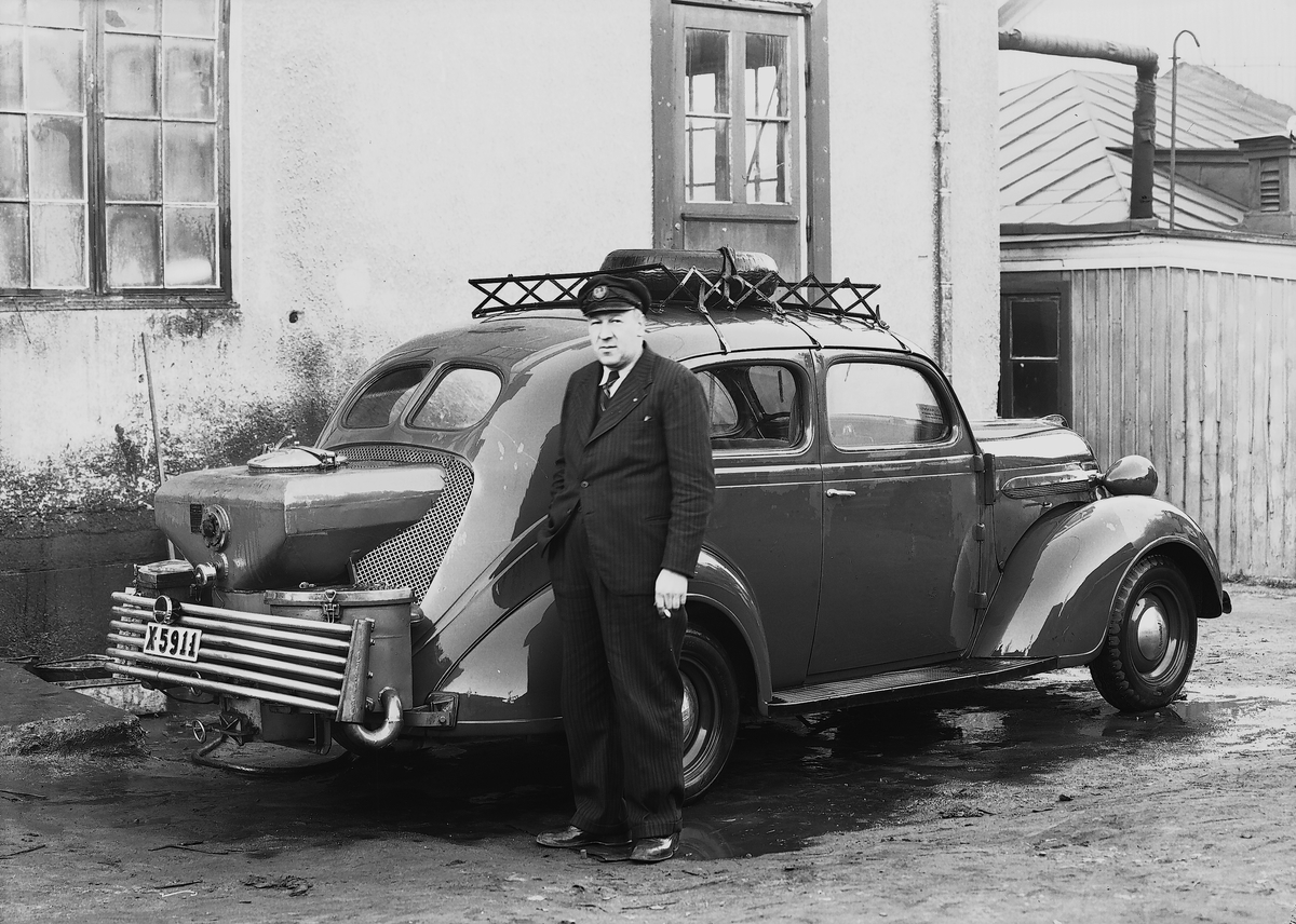 En chaufför vid en1937 Plymouth P4 med gengasaggregat. Maskincarli AB. Stockholm.
