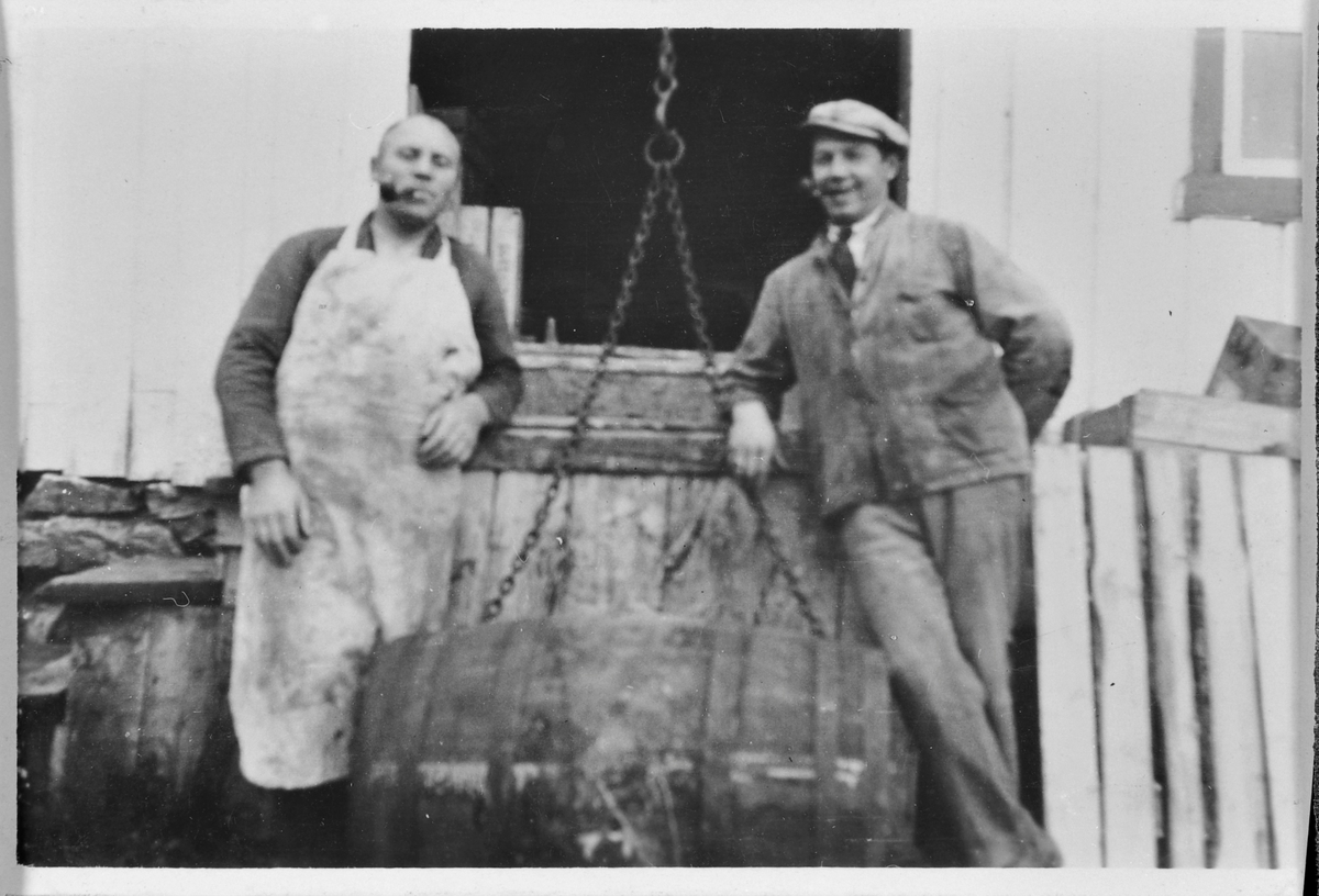Alf Aune og Paul Harøy ved ei tønne utenfor Bjugn Handelssamlag ca. 1933