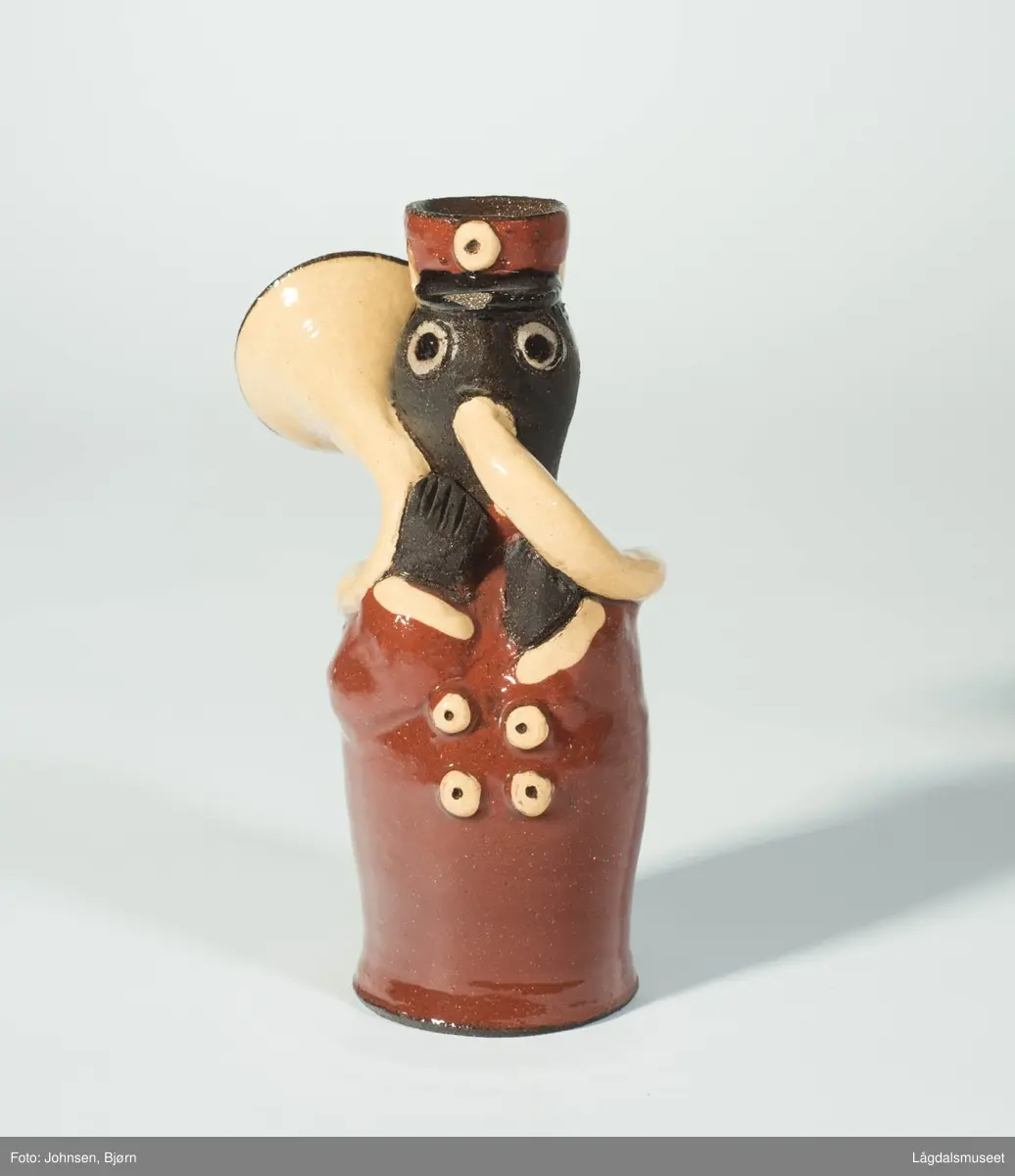 Dekoren på lysestaken utgjør uniformen til musikanten. Utforelsen er en musikant med messinginstrument.