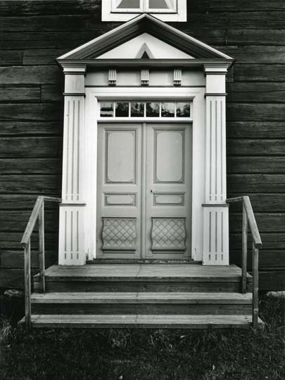 En entré med bemålad dörr och snidad omfattning vid gården Olmats i Undersvik.