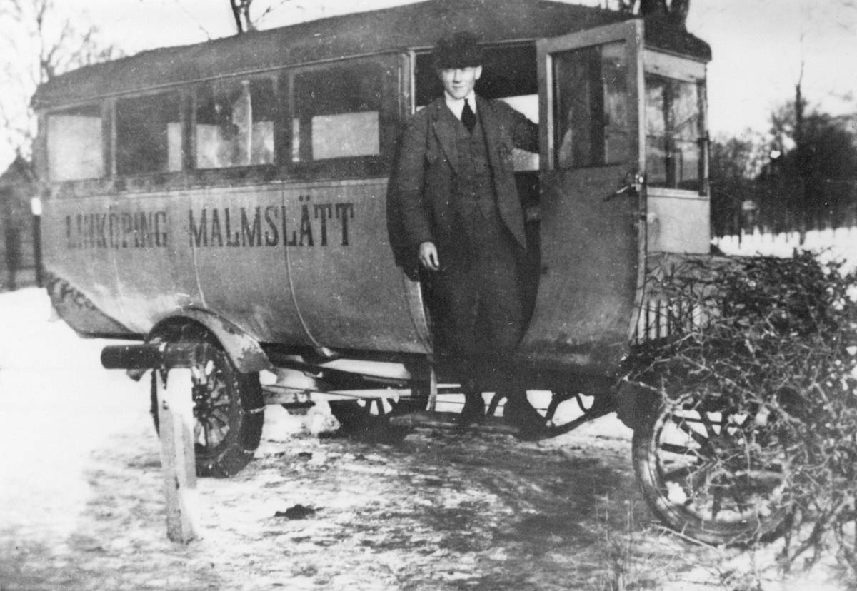 Trafikbussen mellan Linköping och Malmslätt omkring 1915-1935. Förare vid bussdörren.