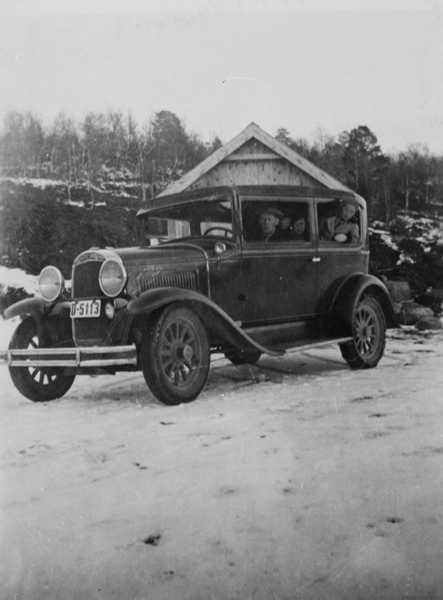 Sjåfør og tre barn på biltur. Bilen var hjemmehørende i Narjordet, Os i Ø. innkjøpt ca. 1928-29. Registreringsnummer D-5113