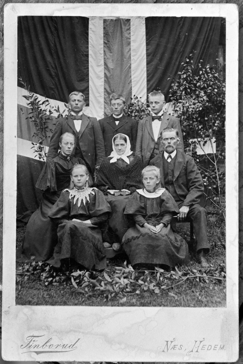 Lars Kristiansen Bye (1839-1917) og Agnete Andersdtr Kvam/Hovde (1843-1900) med familie fotografert foran det norske flagget. Bak fra venstre er Anders (1876-1918), Karl (1872-1963), Knut (1879-1928). Midten fra venstre er Agnes (1874-1946), Agnete og Lars. Foran fra venstre er Tora (1883-1906) og Kristiane (1887-1904).