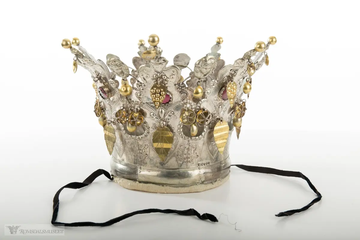 På bøylen mellom delene er loddet på et hode. Hjerte med blomst og blad på hver del.