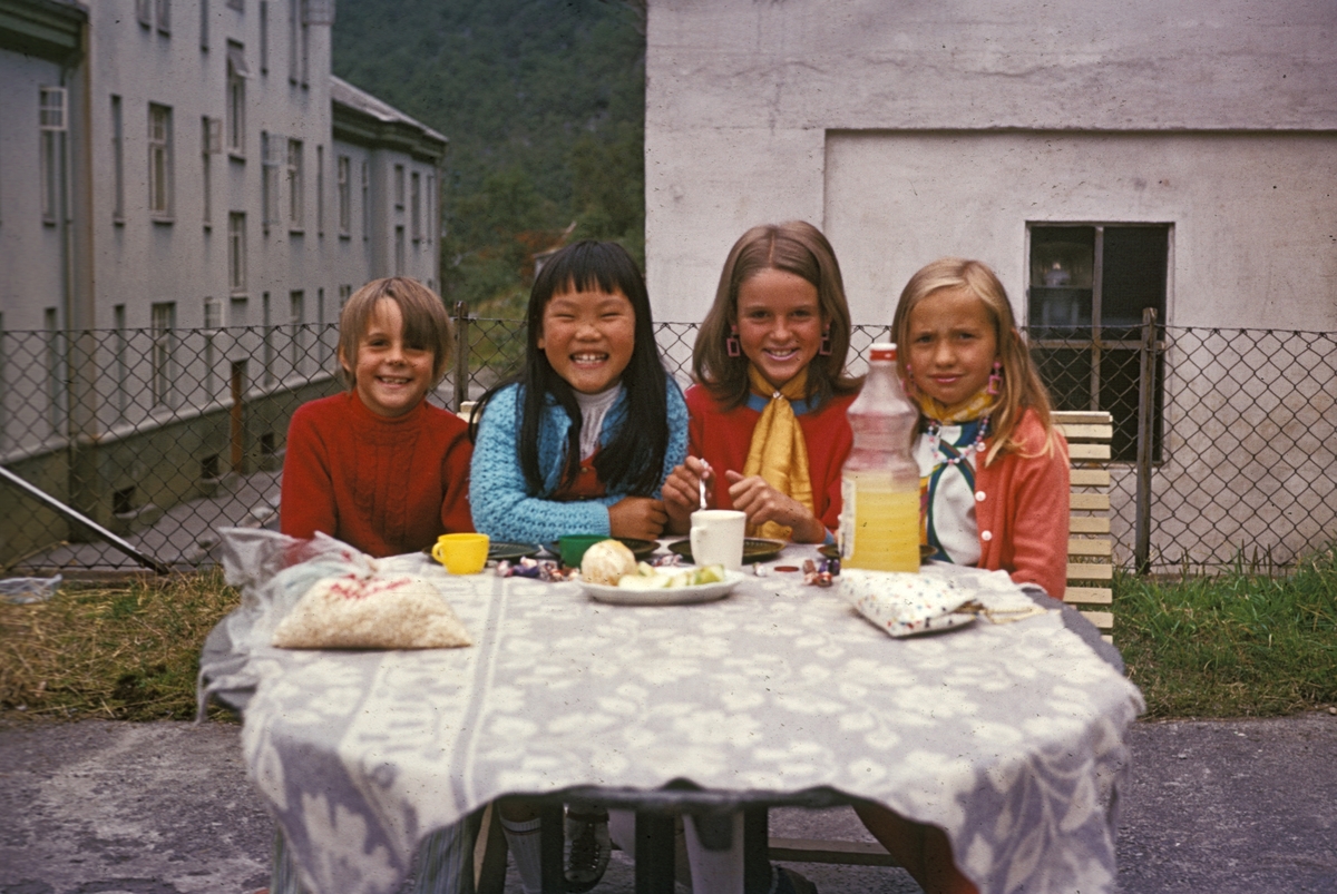 Jenteselskap i hagen, fire blide jenter, Tveitabrotet 8, Slottet i bakgrunnen, hagebenk, bord med duk