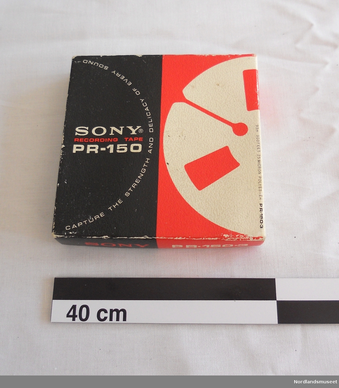 Lydbånd i eske. Type Sony recording tape PR-150-3 etter Lyder Kvantoland. Forseglingstapen er brutt, så det antas at båndet inneholder lydopptak.