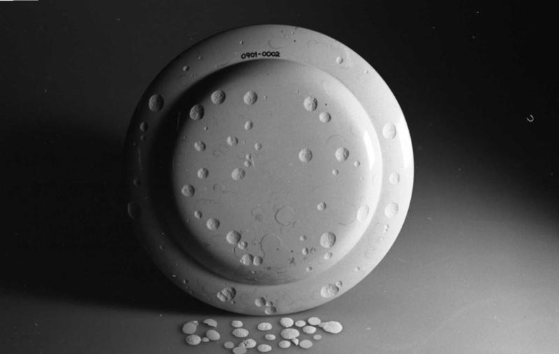Baksida av en hvit tallerken, med flere skår som har falt av. (Foto/Photo)