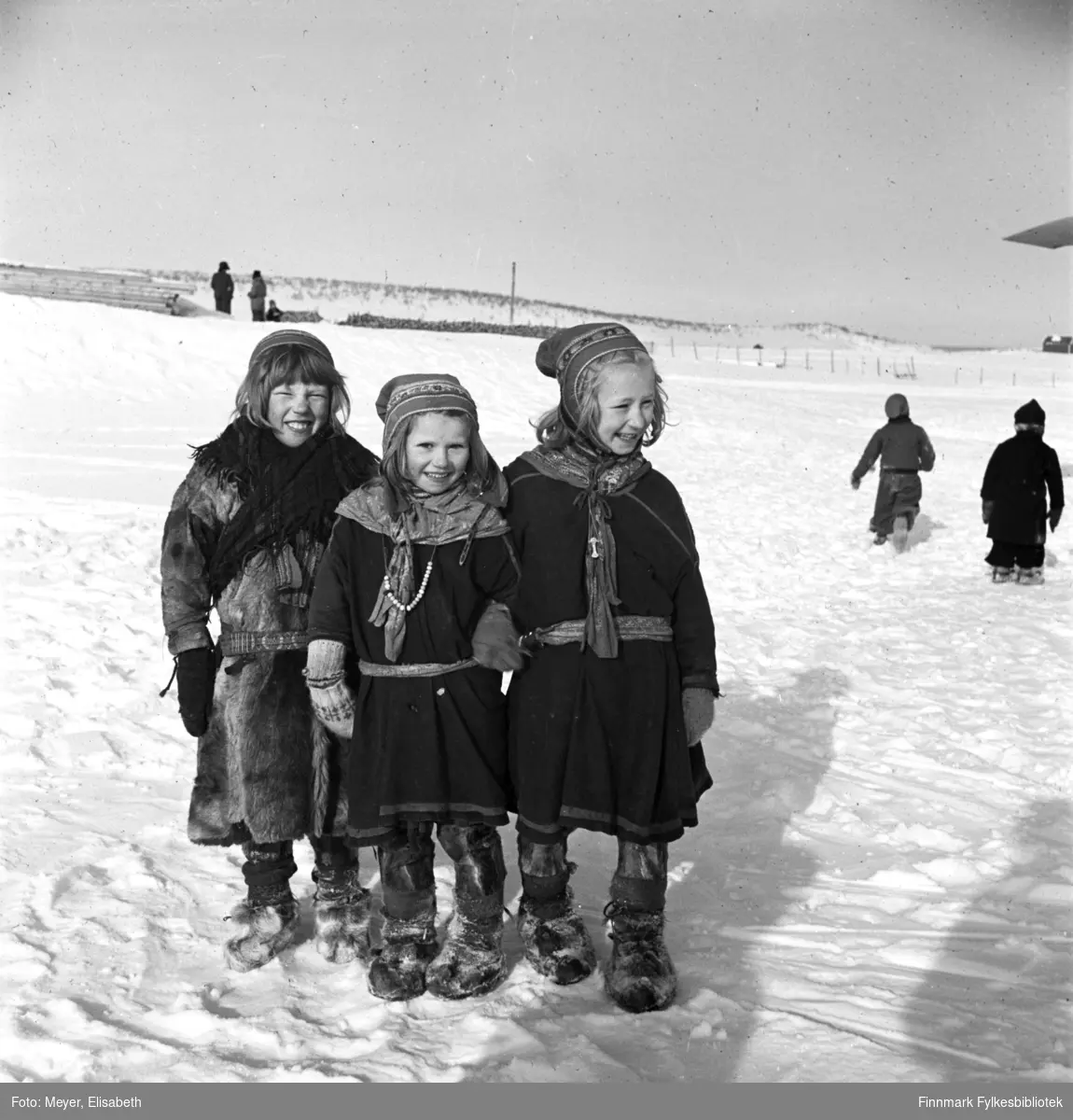 3 venninner fotografert i utenfor Kautokeino Skoleinternat: Berit Anne Persdatter Pentha, , Marit Adamsdatter Triumf, Inga Adamsdatter  Triumf. Bildet er tatt ved påsketider 1940.