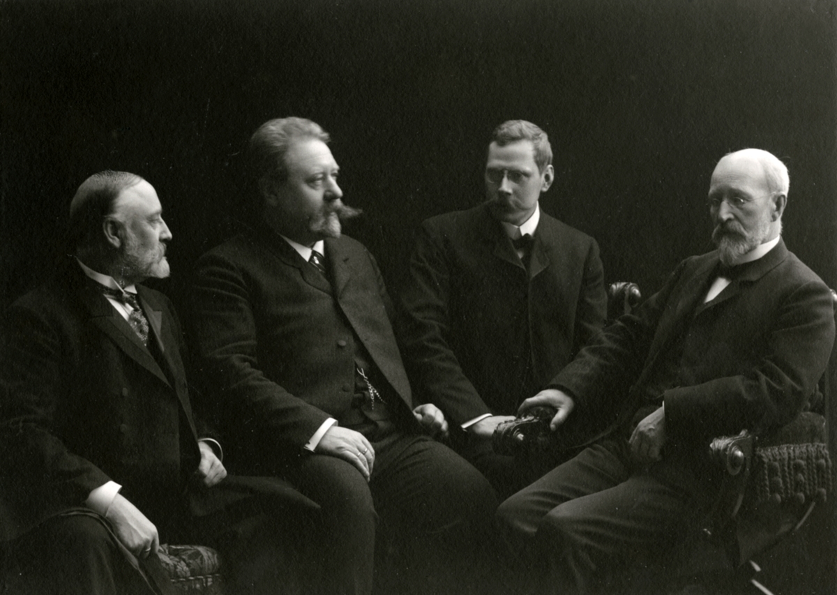 Bildene forestiller fire herrer. Fra venstre: Ukjent, Julius Emil Knudsen, ukjent, Anton Sophus Bachke.