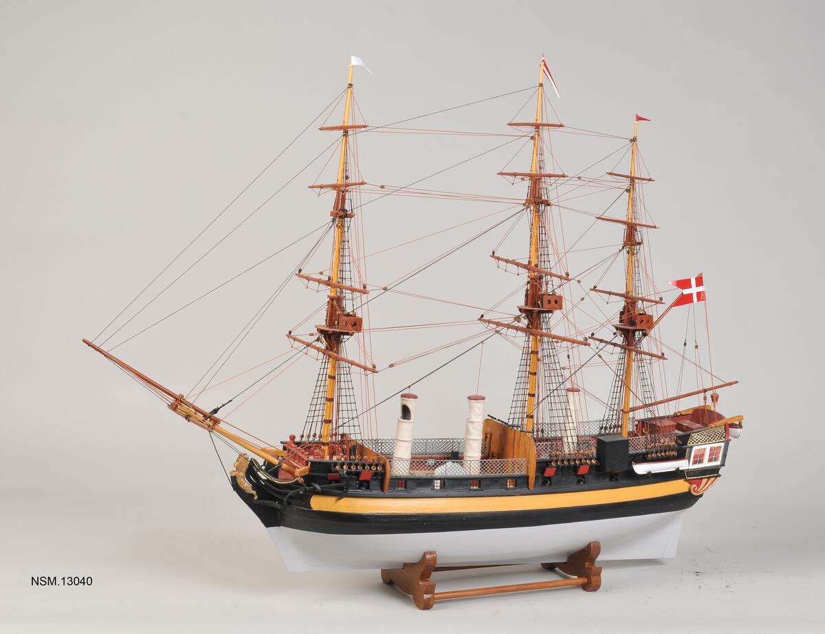 Modell av seilskipet Fredensborg, tre master, baugspryd og et dansk flagg.