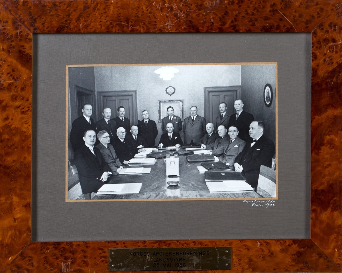 Gruppefoto av møtedeltagere, 17 menn sittende og stående rundt et møtebord.