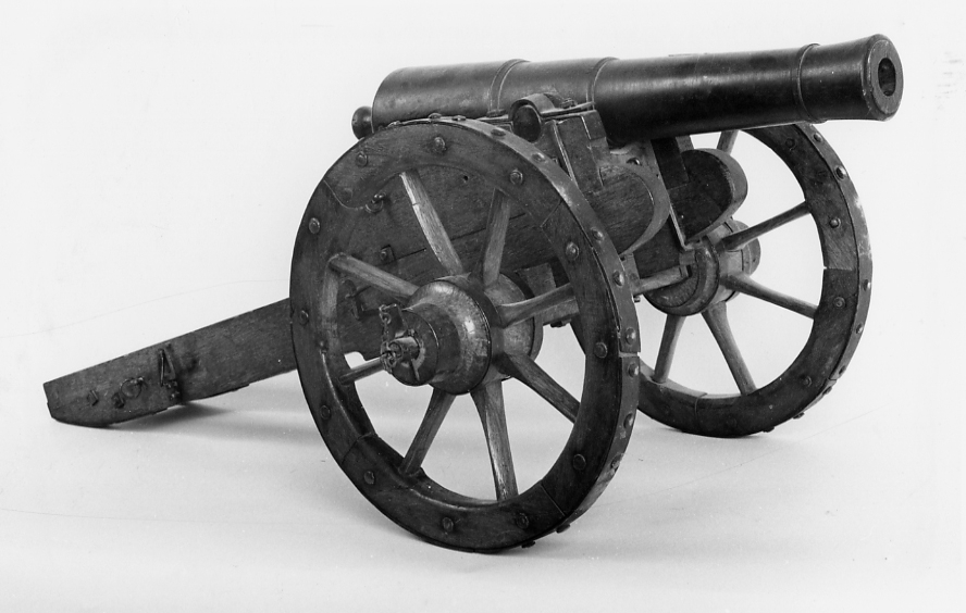 Modell av kanon föreställande en 12-pund landstigningskanon i kursörlavettage av Chapmans modell. Kanon av svartmålat järn. Lavett och kursör av ek med beslag av järn. Lavetten monterad på transportvagn av ek med 2 hjul samt beslag av järn.