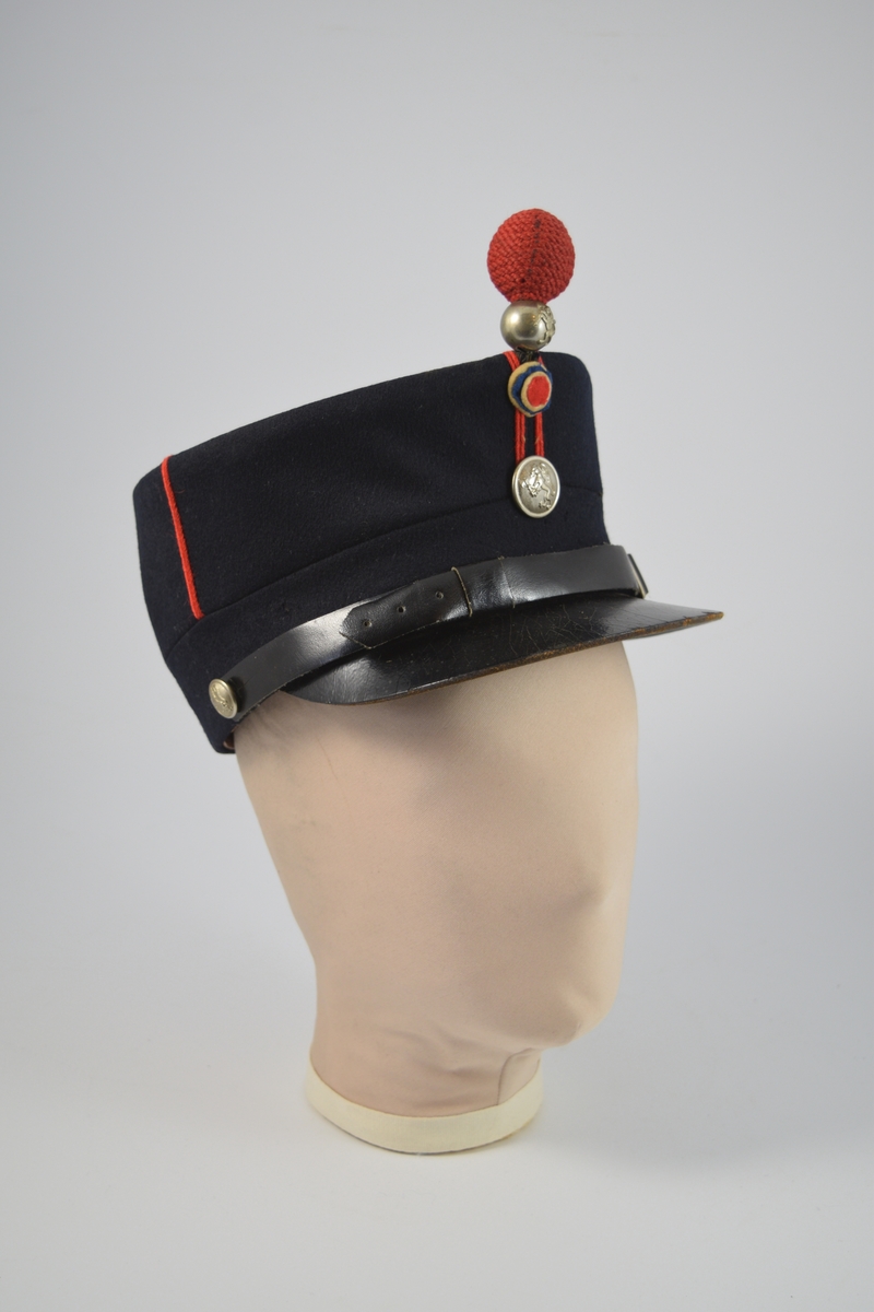 Uniform i to deler, jakke og lue.  a) lett innsvinget m/slag, enkelspent, høy krage; b) bøtteform m/ skygge og distinksjoner