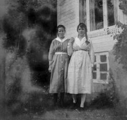 Foto av to kvinner utenfor et bolighus. Det er usikkert hvem