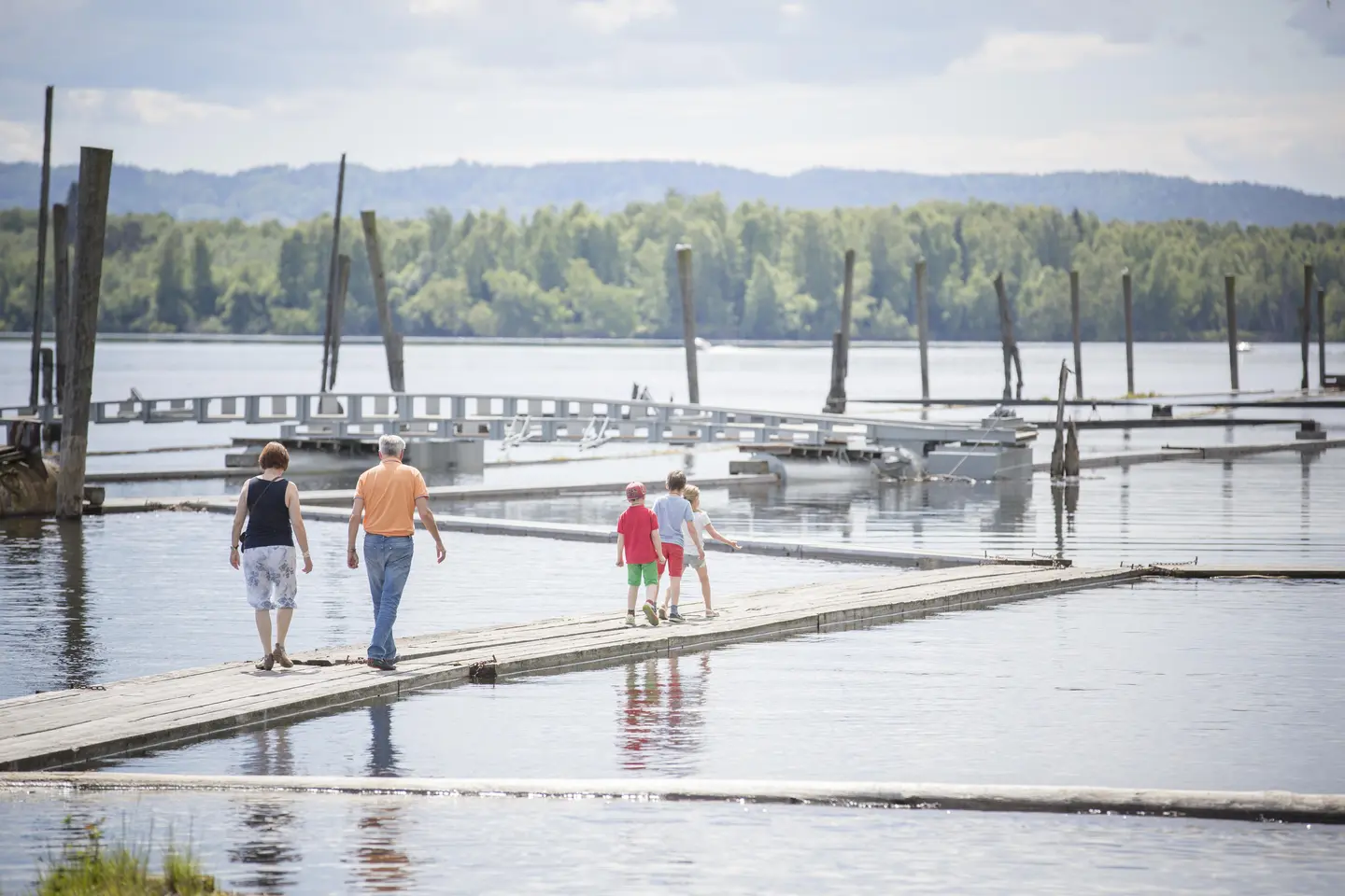 Familie som går på flåtegangene i sorteringsanlegget. Mor, far og tre barn