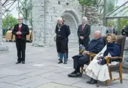 Kong Harald og Dronning Sonja sitter i høyryggede stoler i Hamardomen, ordfører Einar Busterud og avdelingsdirektør Magne Rugsveen står ved siden av.