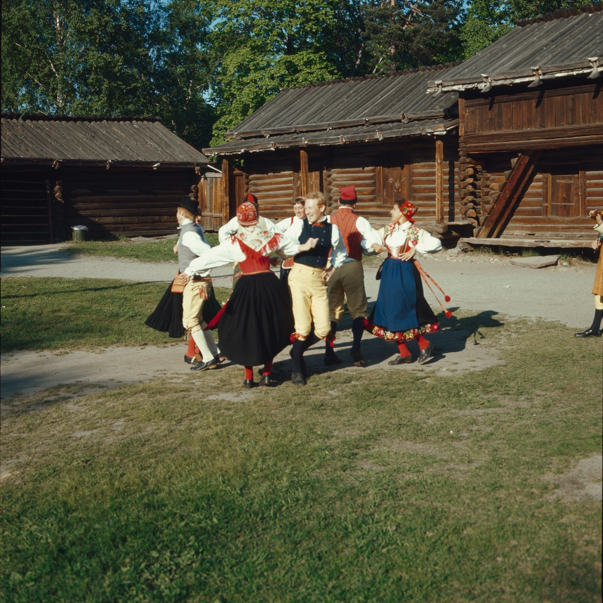 Ett folkdanslag dansar på Moragårdens gårdsplan.