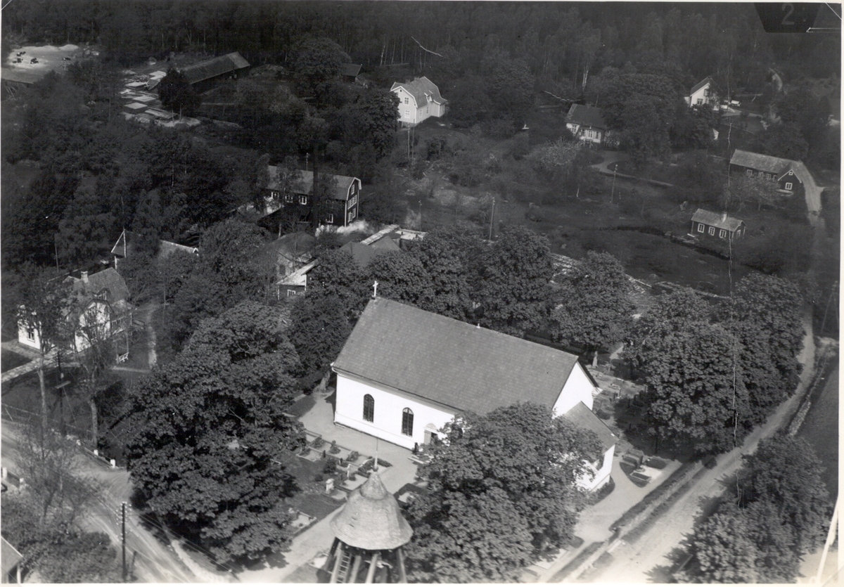 Flygbild över Karlslunda kyrka och kyrkogård i Påryd från sydost. I förgrunden syns klockstapelns huv.