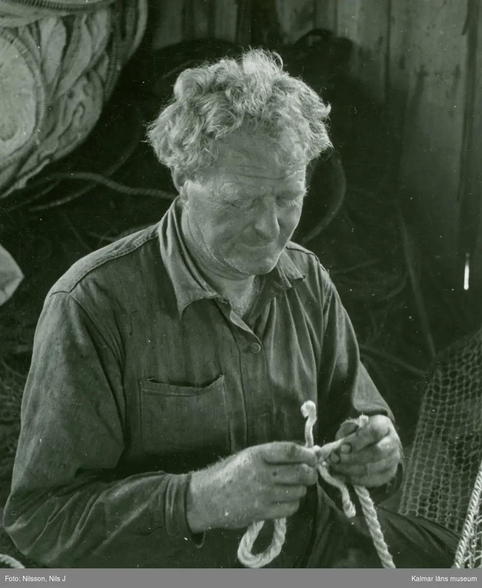 En fiskare på Hornsudden lagar sitt nät.