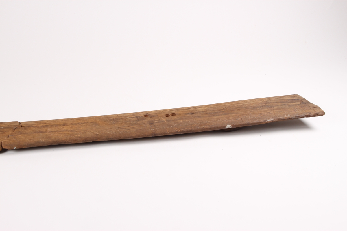 Enkeltski i tre deler med en bred styrerand under. Skien består hovedsakelig av bakski, bindingshull og et lite stykke framski. Bakskien har en avsmalnende form. Bindingshullet er ødelagt. Oversiden av skien har spor etter linjer og er et tidlig eksempel på strekmåtdekor.