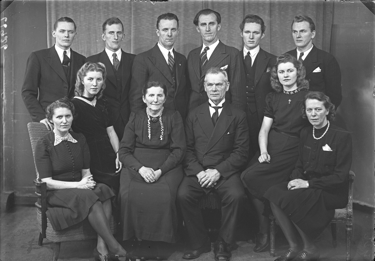 Gruppebilde. Familie. Gruppe på 12, en eldre mann, ei eldre kvinne, seks unge menn og fire unge kvinner.  Bestilt av Claus Dale. Skudenes.