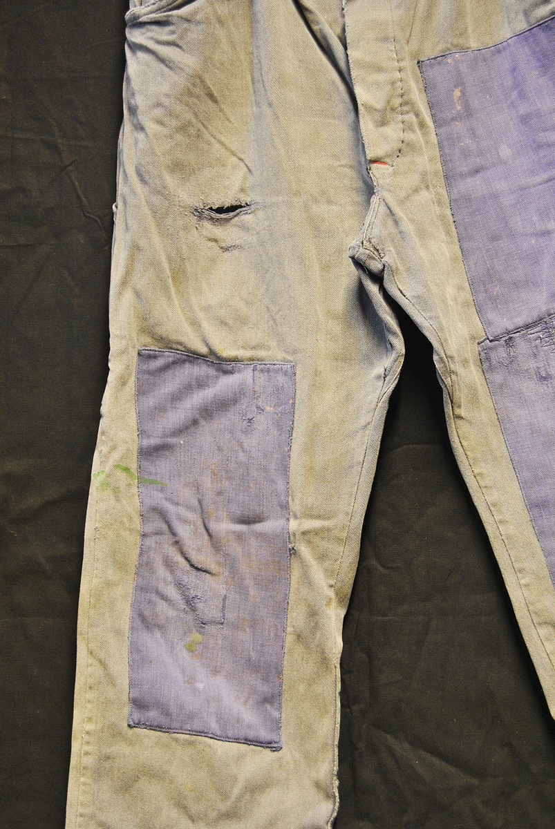 Arbeidsbukse av dongristoff. Bærer preg av bruk. Lappet flere ganger.