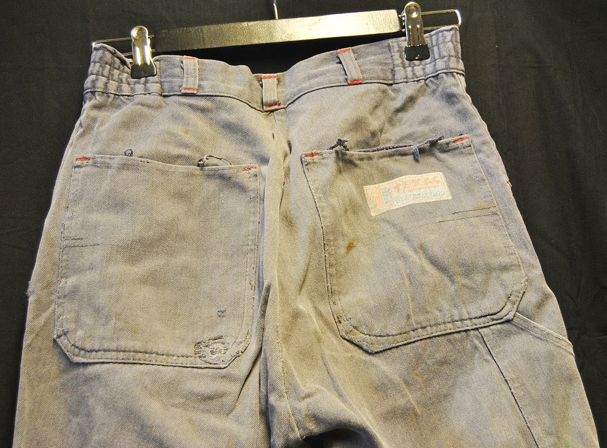 Arbeidsbukse av dongristoff. Bærer preg av bruk. Lappet flere ganger.